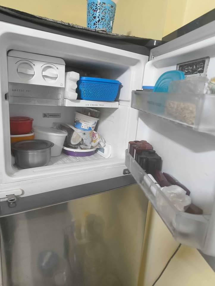 Open Whirlpool triple door convertible refrigerator freezer compartment with food containers and door shelf storage