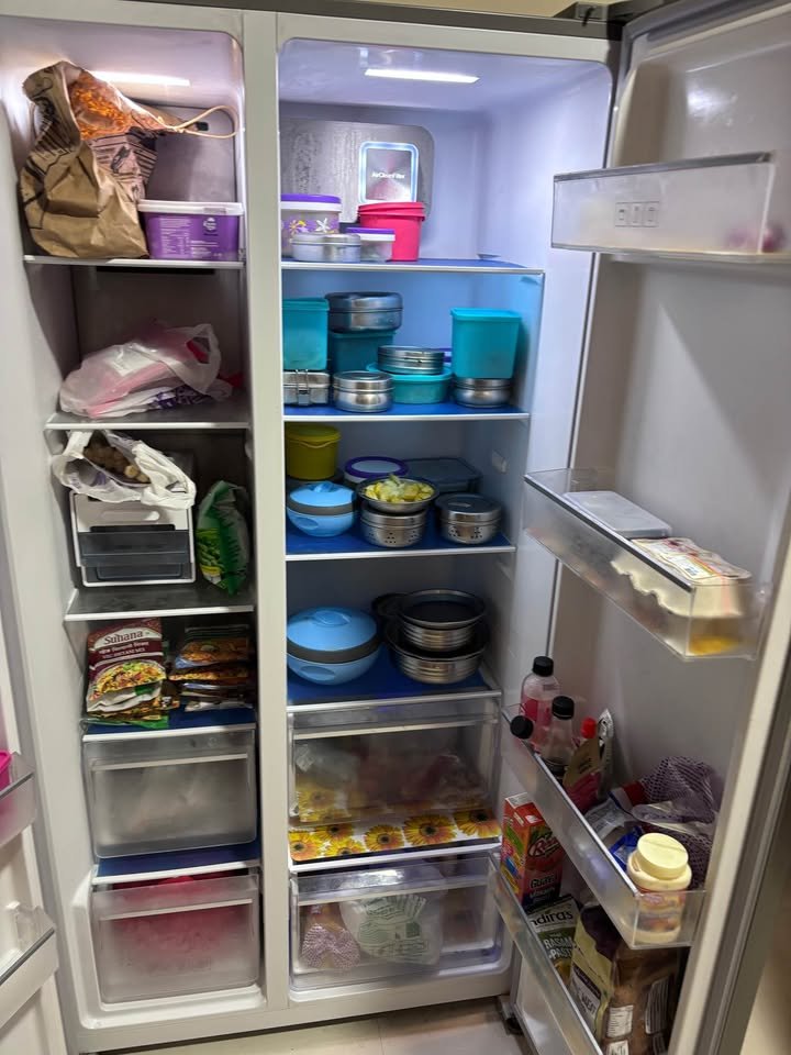 Voltas Beko 563 L side by side refrigerator freezer compartment showing multiple shelves and bottom freezer drawers for frozen food storage.