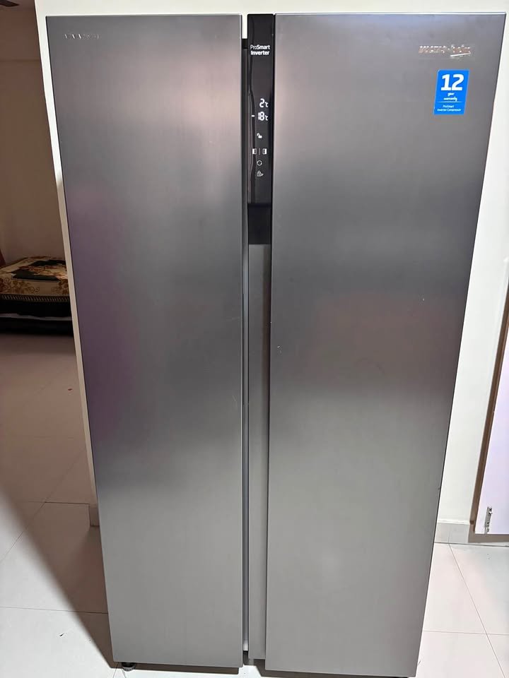Front view of Voltas Beko 563 L side by side refrigerator in silver finish with central digital control panel.